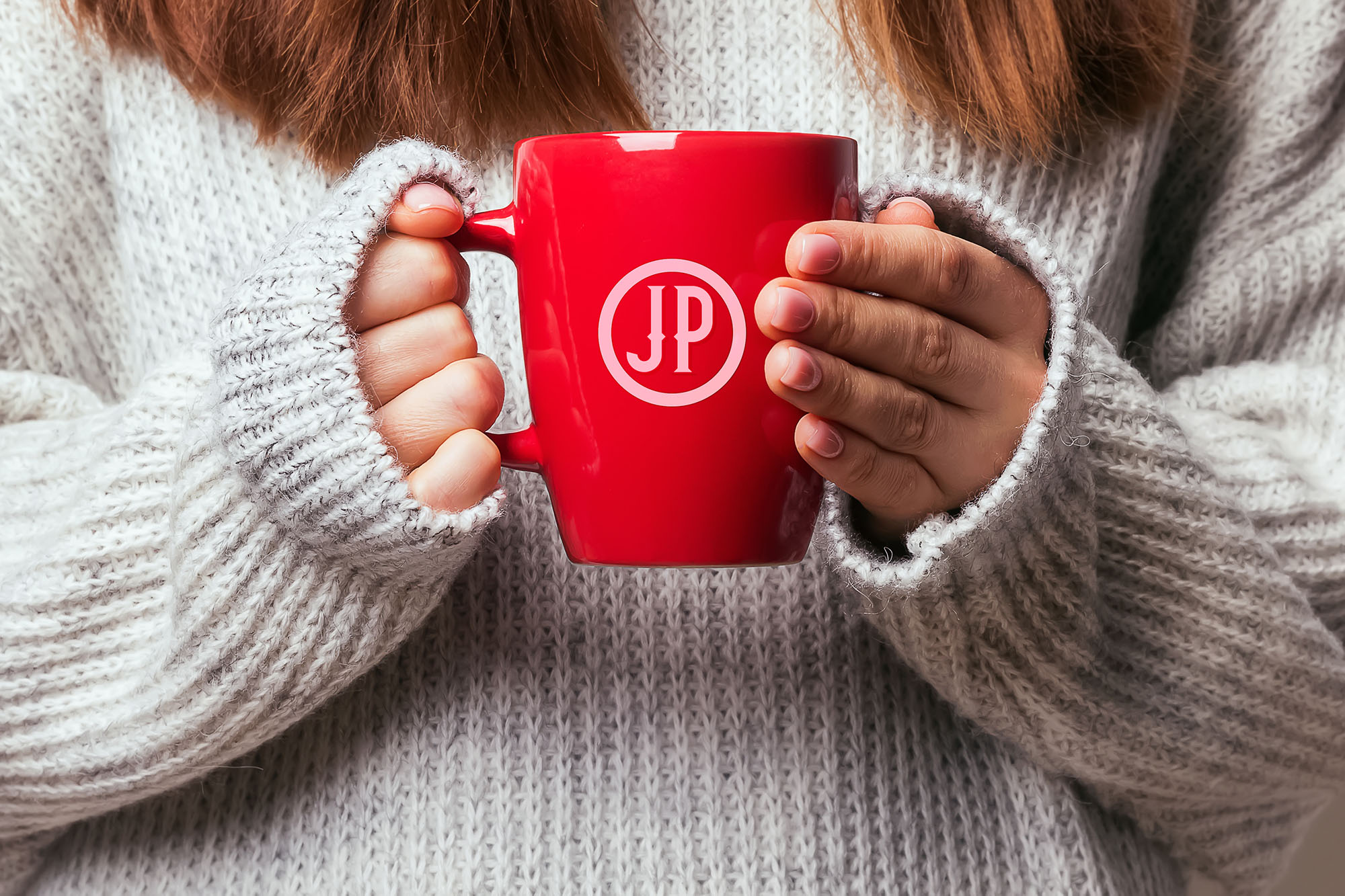 Picture of a woman's hands holding a red coffee mug