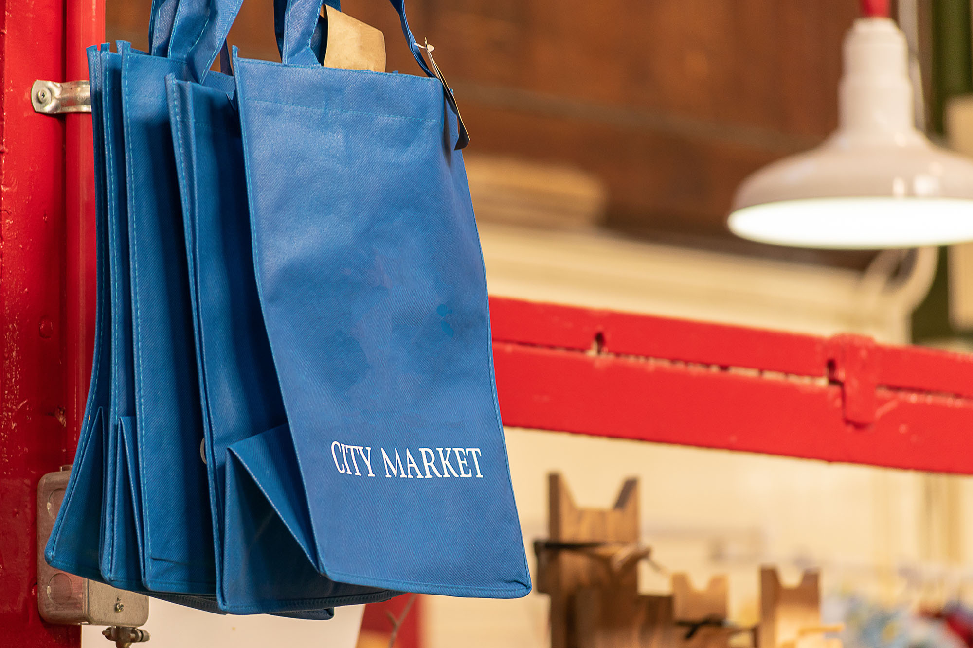 Blue foldable reusable shopping bags for sale at a Market.